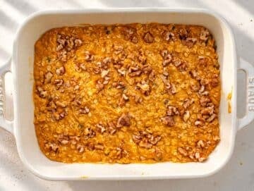 Step 3 Unbaked pumpkin oatmeal topped with chopped walnuts in a white dish.