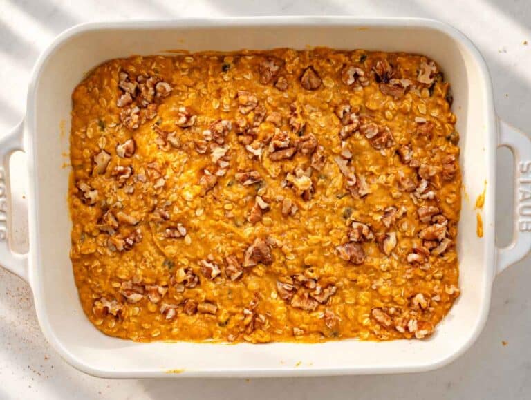 Step 3 Unbaked pumpkin oatmeal topped with chopped walnuts in a white dish.