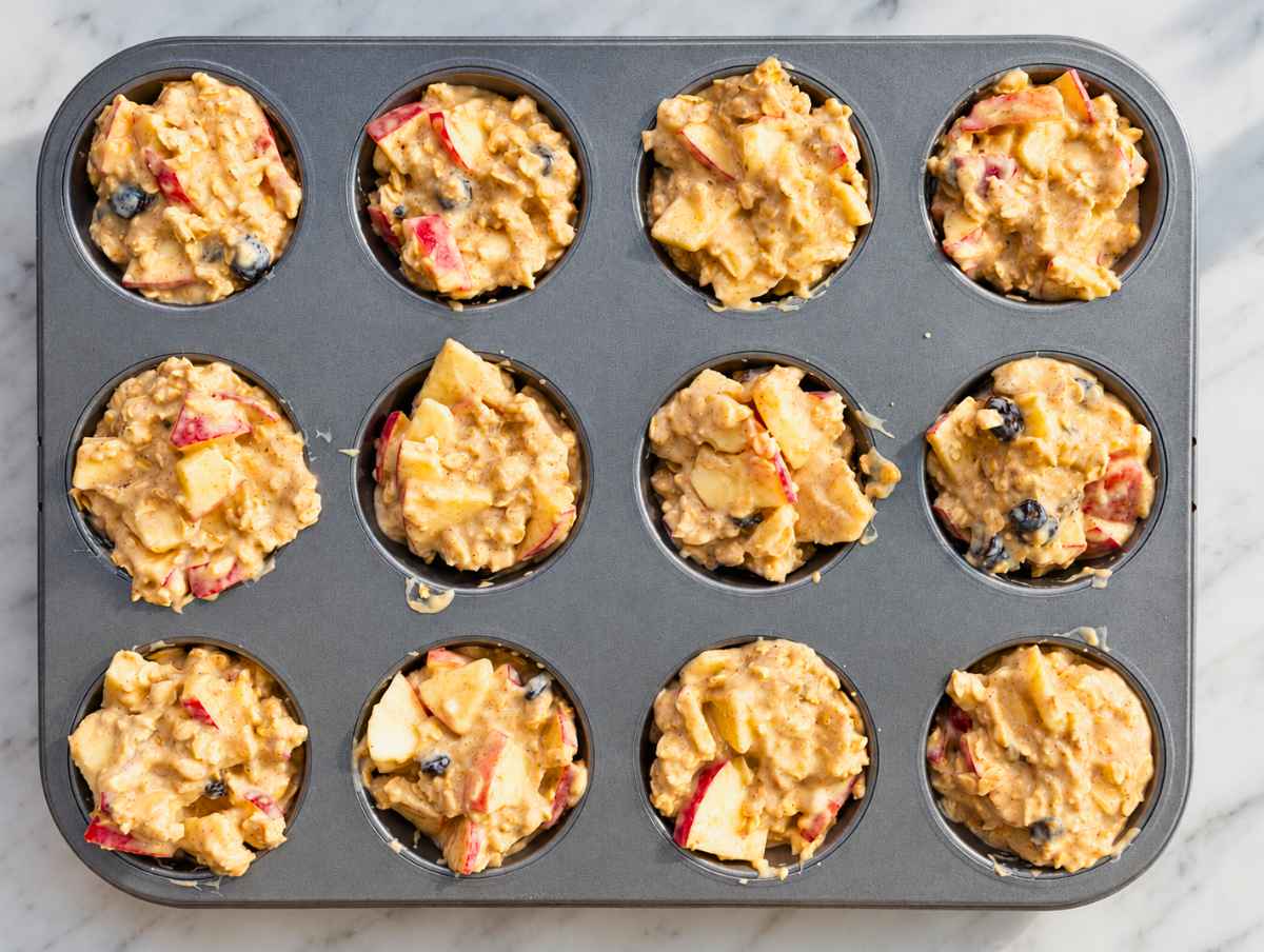 Step 3 apple oatmeal cups in baking pan before baking in the oven.