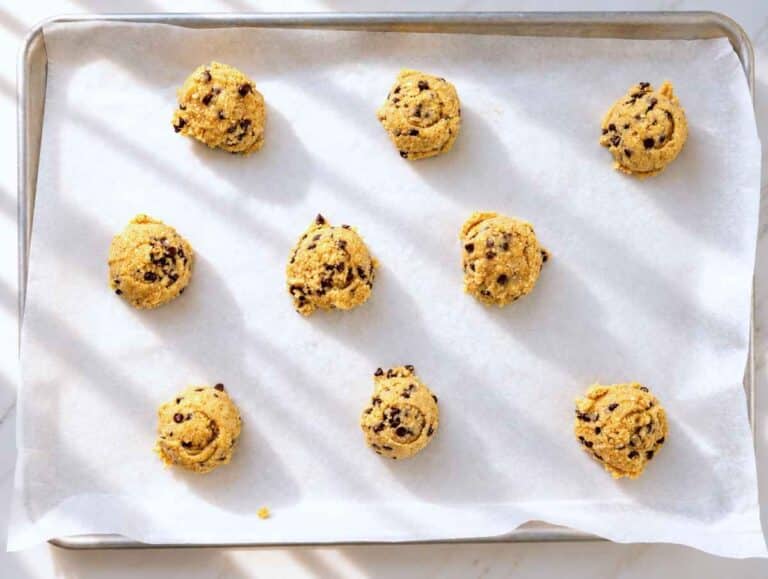 Step 3 – Tall, rounded scoops of cookie dough on a parchment-lined baking sheet.