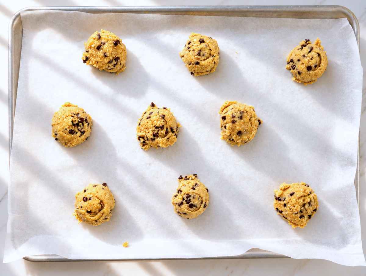 Step 3 – Tall, rounded scoops of cookie dough on a parchment-lined baking sheet.
