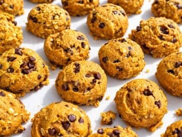 Step 4 Baked pumpkin cookies cooling on parchment, with set tops and chocolate chips.