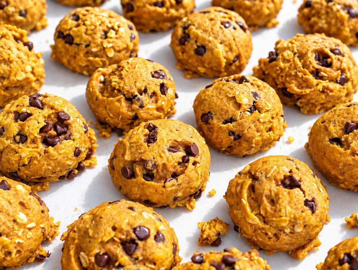 Step 4 Baked pumpkin cookies cooling on parchment, with set tops and chocolate chips.