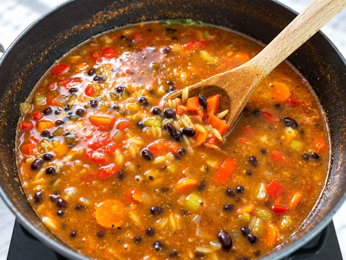 Step 4 Orzo cooking among black beans and vegetables in thickening broth.