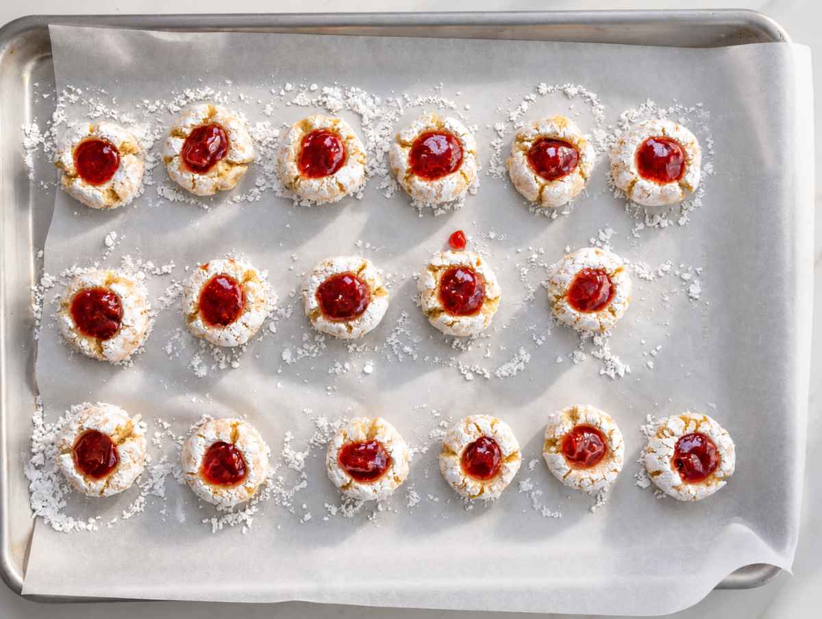 Step 4 Unbaked almond cookies with thumbprint centers filled with raspberry jam.